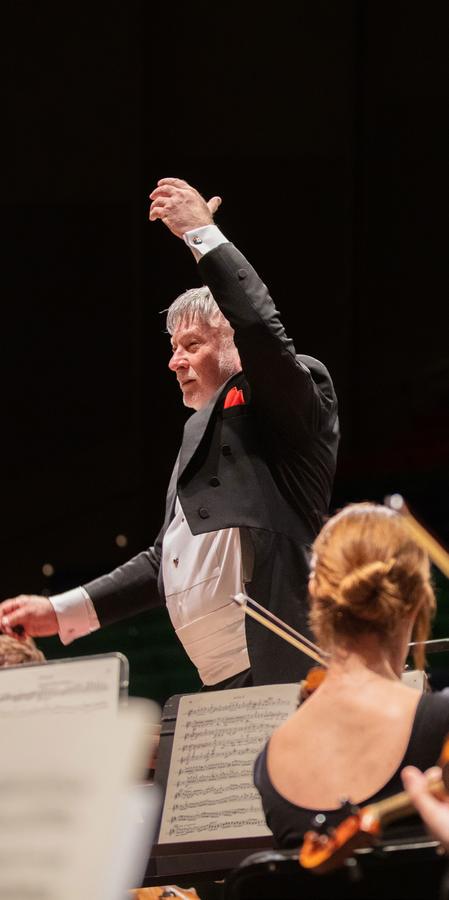 A conductor leads the Des Moines Symphony